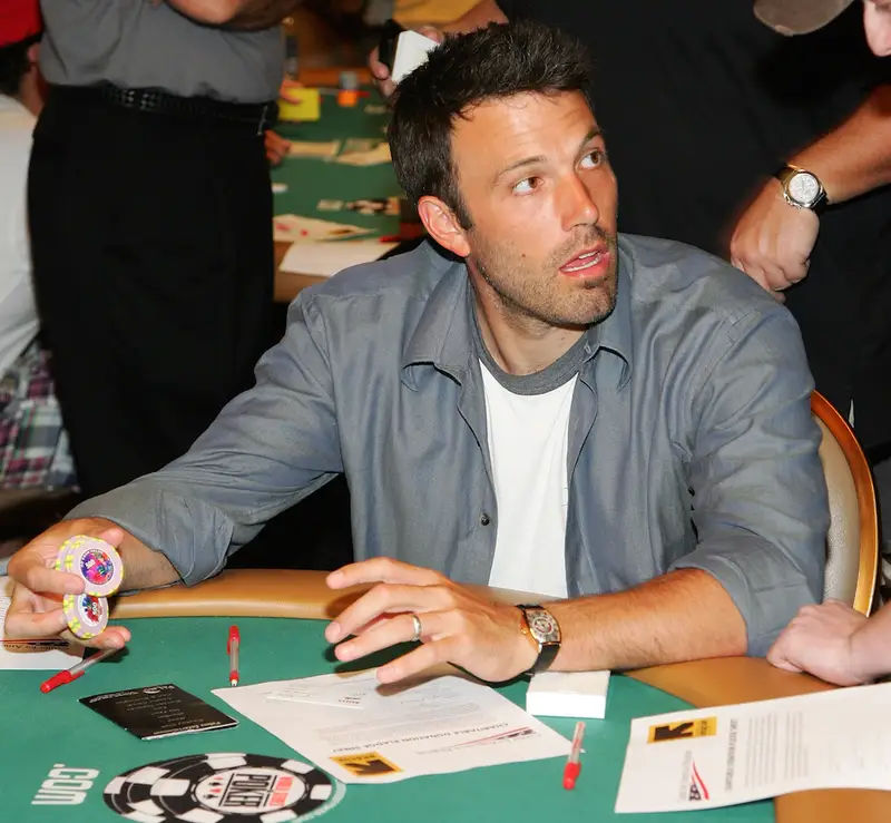 A celebrity poker table with cards and chips in play