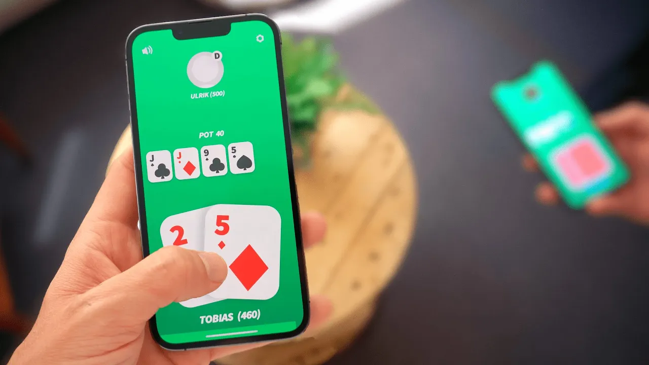 Poker cards and chips laid out beside a phone showing hand statistics