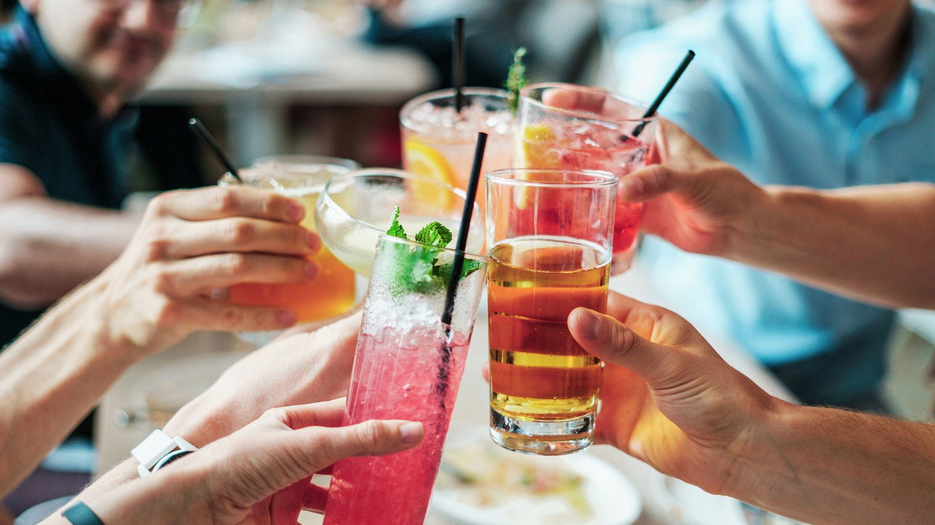 Friends toasting with drinks around a table